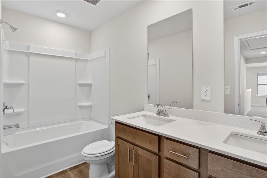 6929 Winchester Place Fairburn, GA 30213 - Photo 26 of 35 a bathroom with a sink a toilet and a large mirror