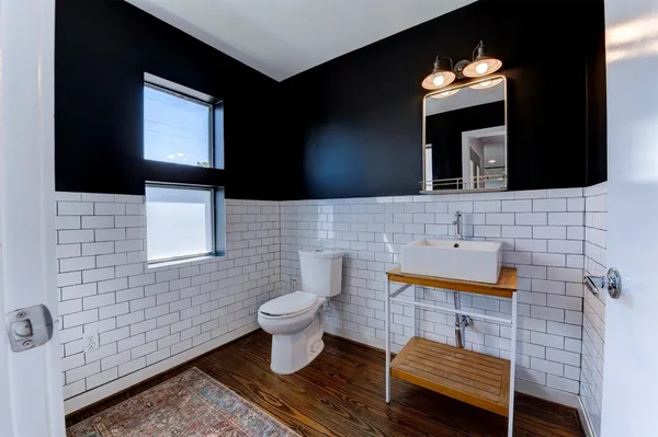 a bathroom with a toilet sink and mirror