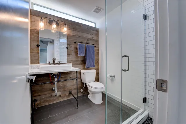a bathroom with a double vanity sink toilet and shower