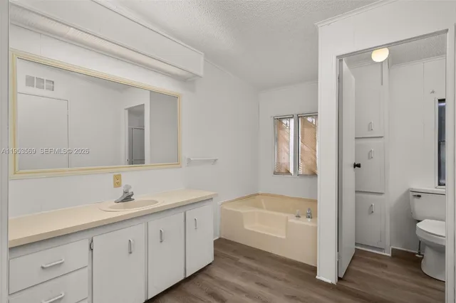 a bathroom with a double vanity sink a mirror and a bathtub