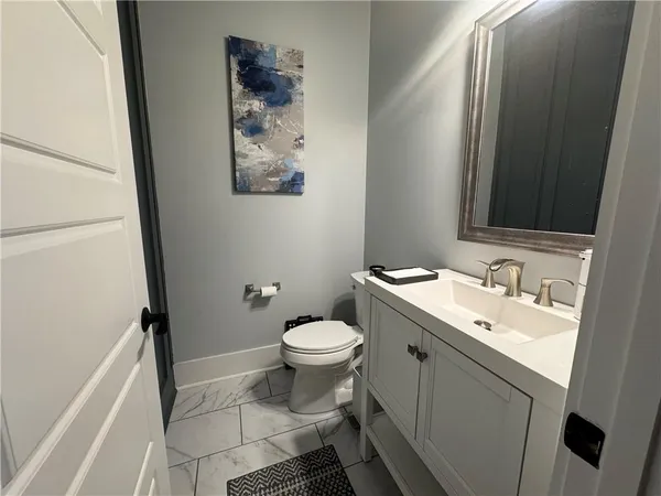 a bathroom with a toilet sink and mirror