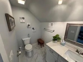 a bathroom with a toilet sink and mirror