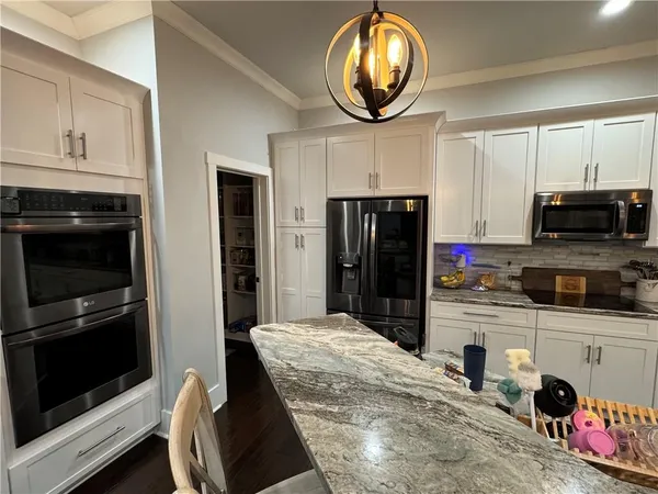 a kitchen with stainless steel appliances granite countertop a stove refrigerator and microwave