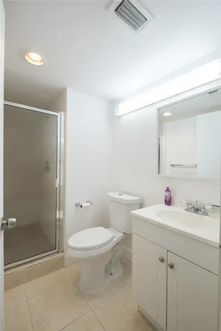 a bathroom with a toilet sink vanity and shower
