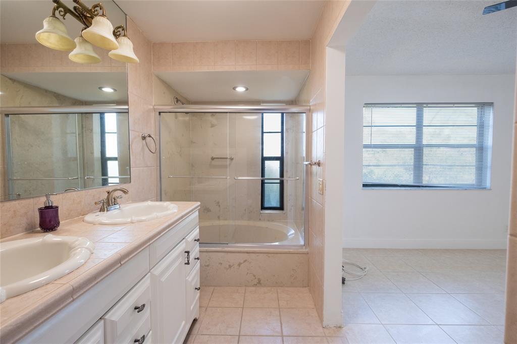 9233 Southwest 8th Street, Unit 222 Boca Raton, FL 33428 - Photo 22 of 29 a bathroom with a tub sink and mirror