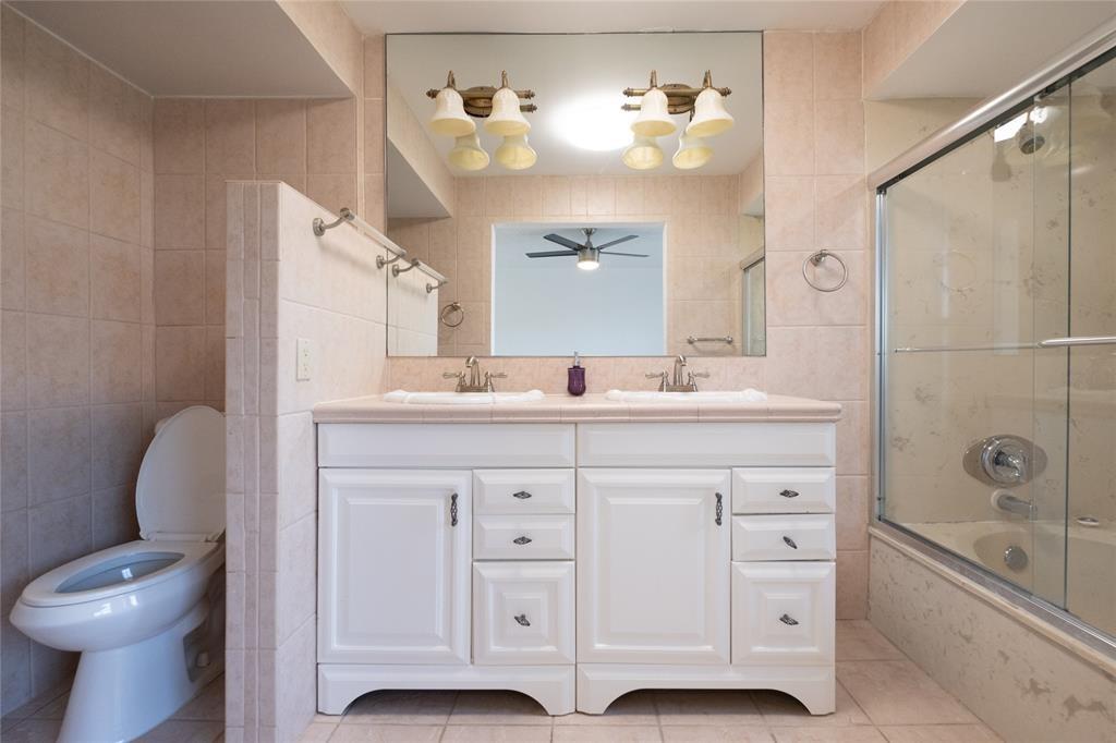 9233 Southwest 8th Street, Unit 222 Boca Raton, FL 33428 - Photo 25 of 29 a bathroom with a granite countertop sink toilet and shower