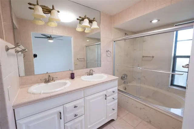 a bathroom with a granite countertop sink a mirror a shower and a bathtub