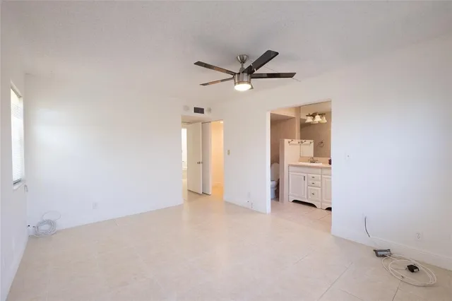 a view of a livingroom with a ceiling fan and refrigerator