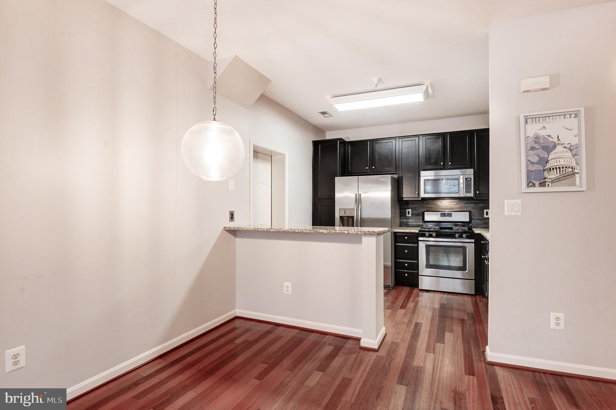 11407 Gate Hill Place, Unit 112 Reston, VA 20194 - Photo 11 of 28 a kitchen with stainless steel appliances a refrigerator and a stove top oven