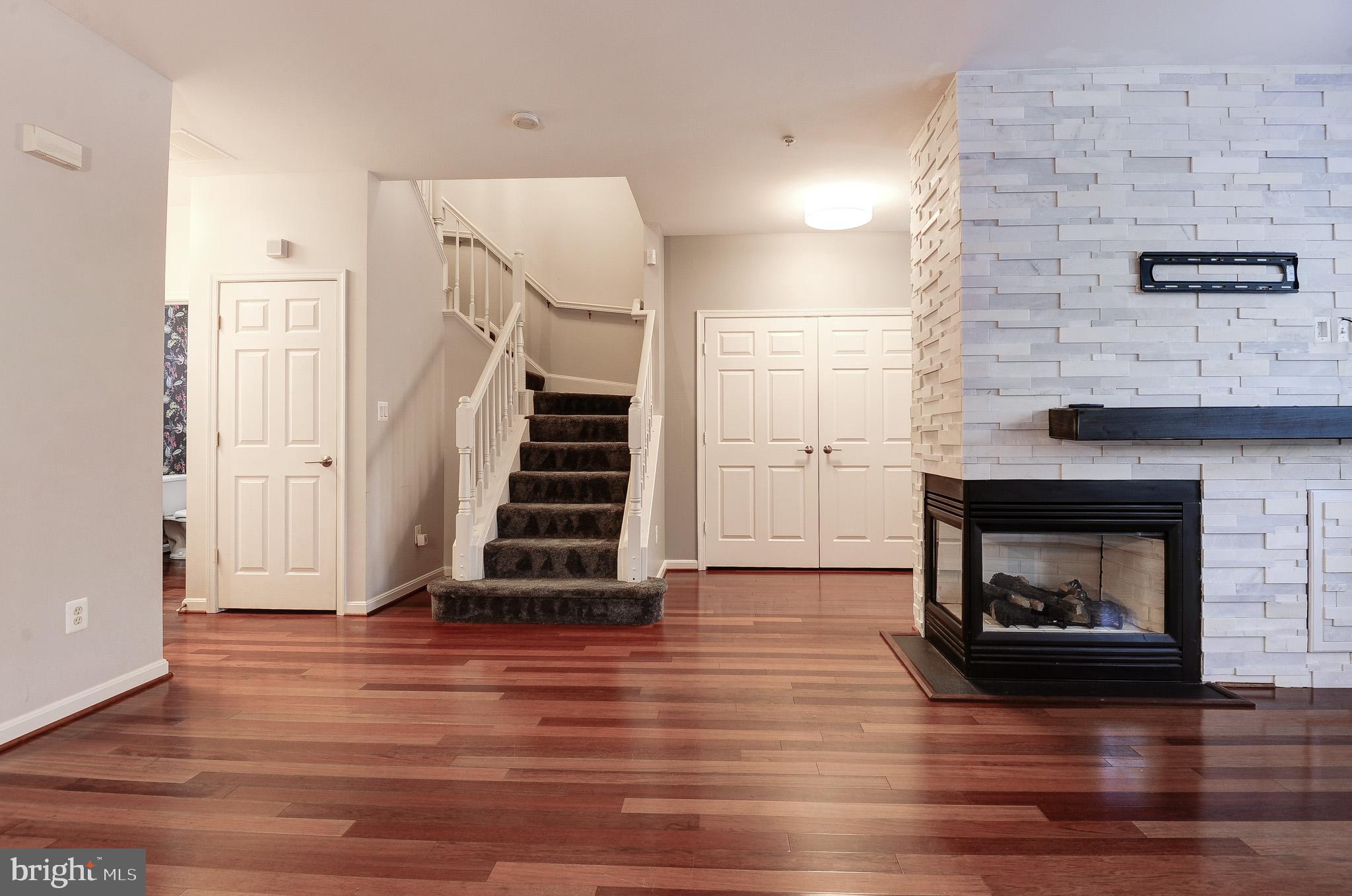 11407 Gate Hill Place, Unit 112 Reston, VA 20194 - Photo 28 of 28 a view of a livingroom with wooden floor and a fireplace