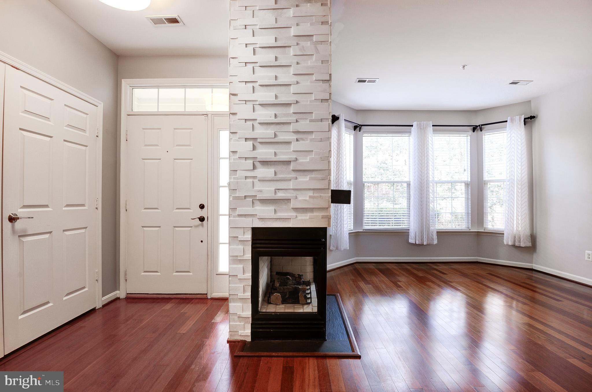 11407 Gate Hill Place, Unit 112 Reston, VA 20194 - Photo 4 of 28 wooden floor fireplace and windows in an empty room