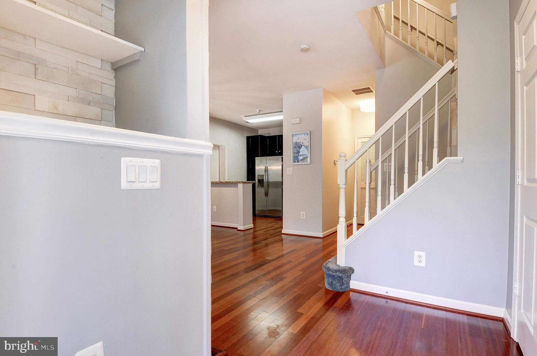 11407 Gate Hill Place, Unit 112 Reston, VA 20194 - Photo 5 of 28 a view of a hallway with wooden floor and staircase