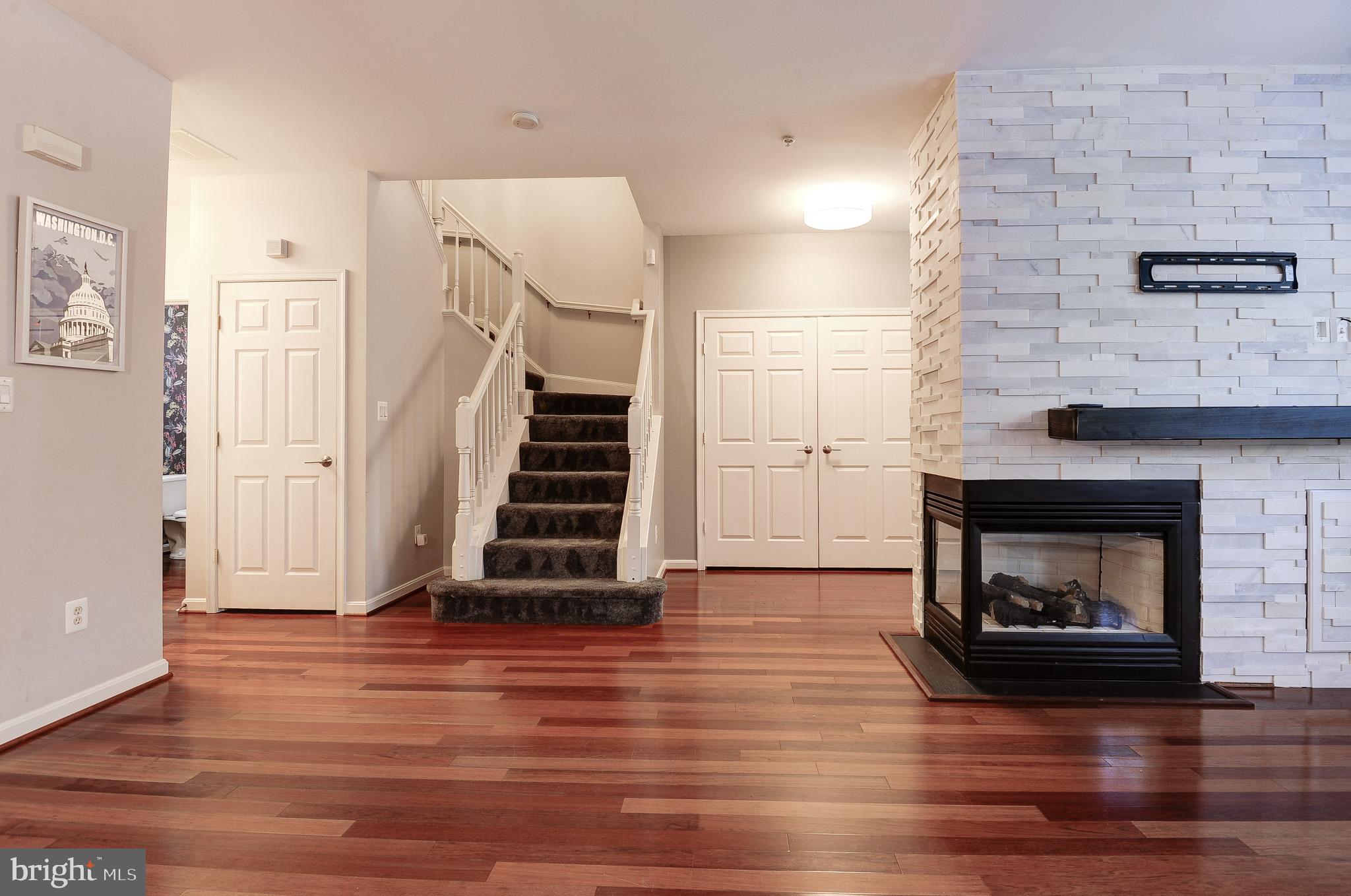 11407 Gate Hill Place, Unit 112 Reston, VA 20194 - Photo 8 of 28 a view of a livingroom with wooden floor and a fireplace