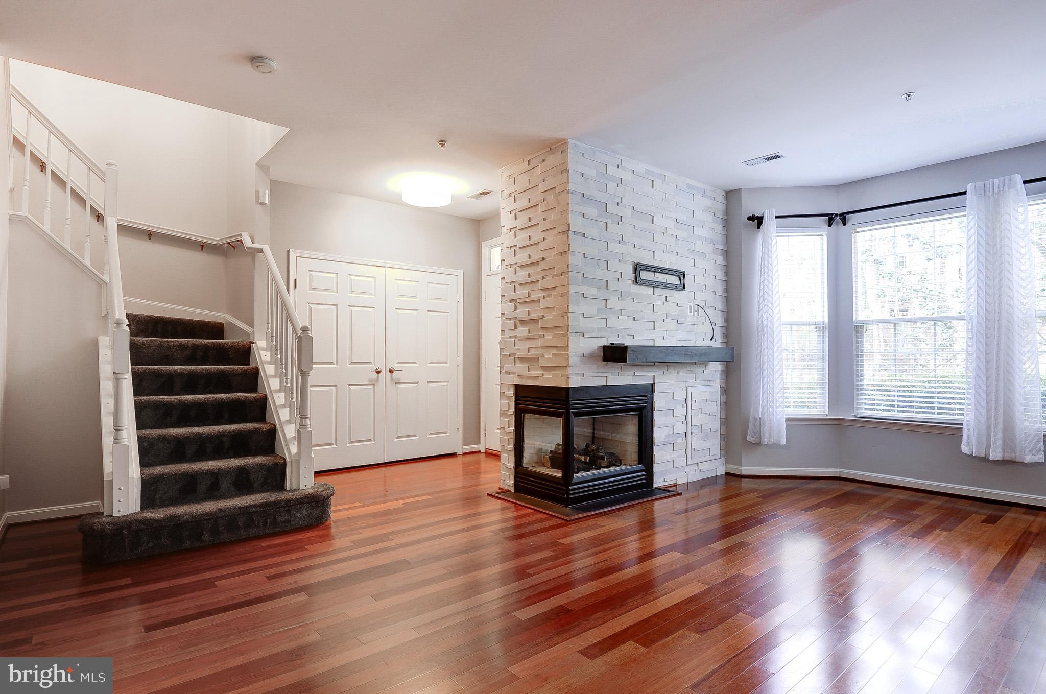 11407 Gate Hill Place, Unit 112 Reston, VA 20194 - Photo 9 of 28 a view of wooden floor fire place and windows in a room