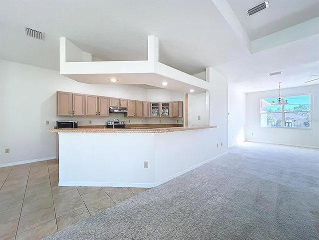 a view of a kitchen with a sink and a chandelier fan