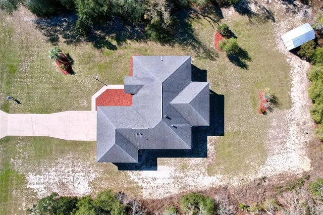 an aerial view of a house with a yard and pool