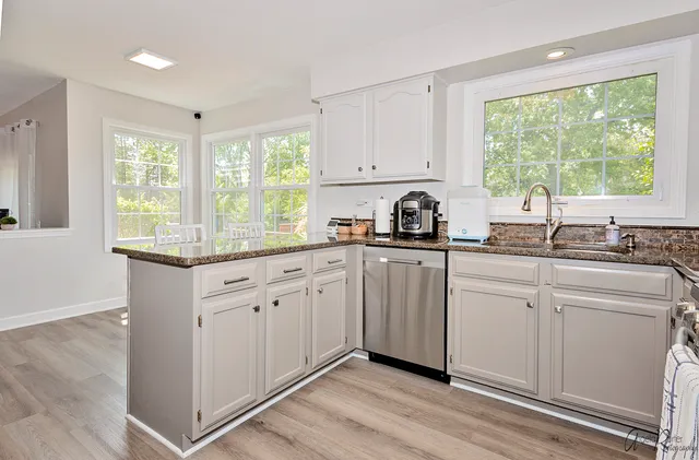 a kitchen with sink a window and cabinets