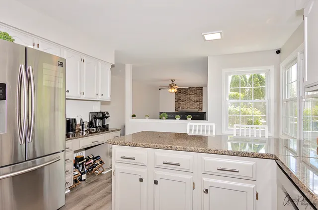 a kitchen with granite countertop a refrigerator and a sink