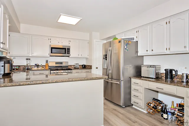 a kitchen with granite countertop a refrigerator and a sink