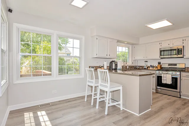 a kitchen with stainless steel appliances granite countertop a stove top oven a sink dishwasher and a refrigerator