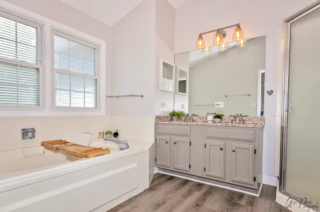 a bathroom with a tub sink and mirror