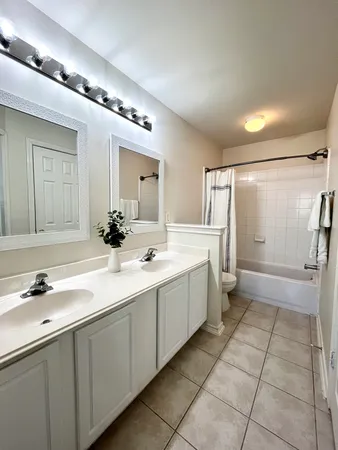 a spacious bathroom with a double vanity sink and mirror