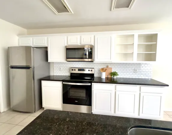 a kitchen with a refrigerator stove and microwave