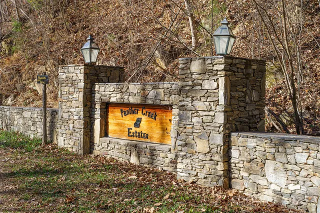 a view of a brick house with large trees