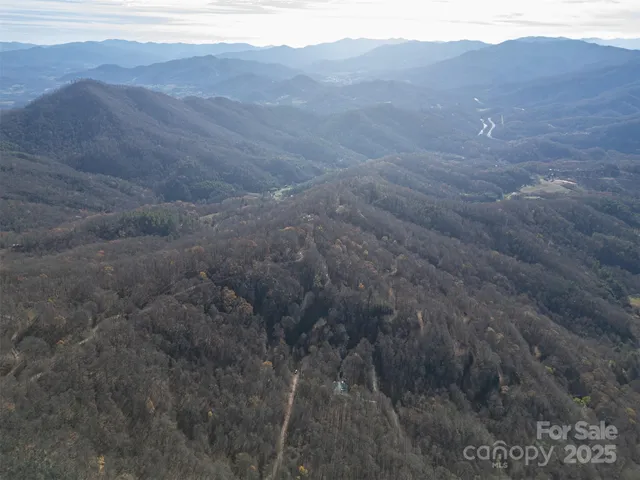 a view of a dry yard with mountains in the background
