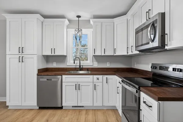 a kitchen with stainless steel appliances granite countertop a sink and cabinets with wooden floor