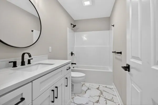 a bathroom with a sink a toilet and a mirror