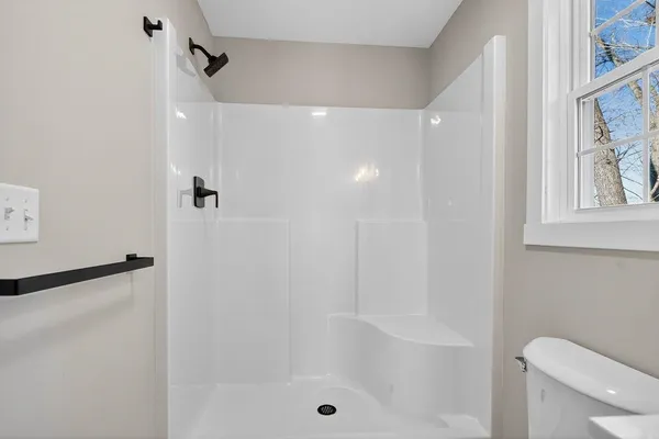 a bathroom with a shower a toilet and a shower