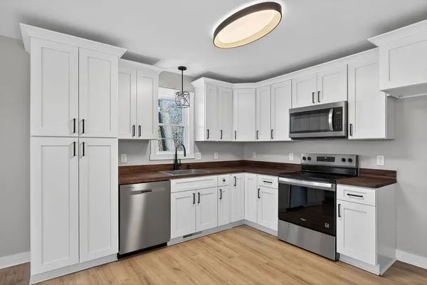 a kitchen with cabinets stainless steel appliances and a sink