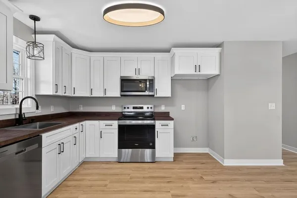 a kitchen with stainless steel appliances granite countertop a sink a stove a refrigerator and cabinets