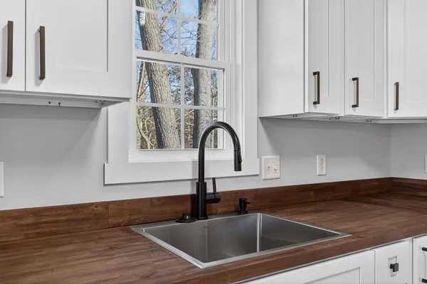 a close view of a sink and dishwasher with wooden floor