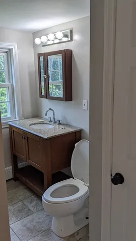 a bathroom with a toilet sink and mirror