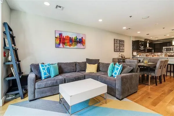 a living room with furniture a rug and a bookshelf