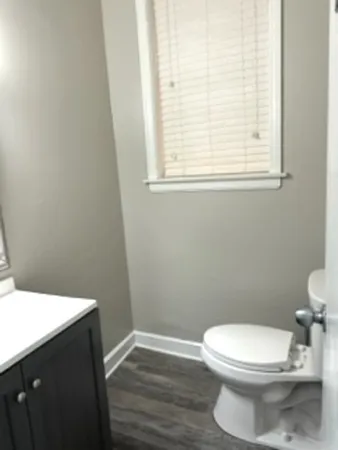 a toilet sitting in a bathroom next to a window
