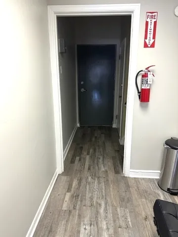 a view of a hallway with wooden floor and closet