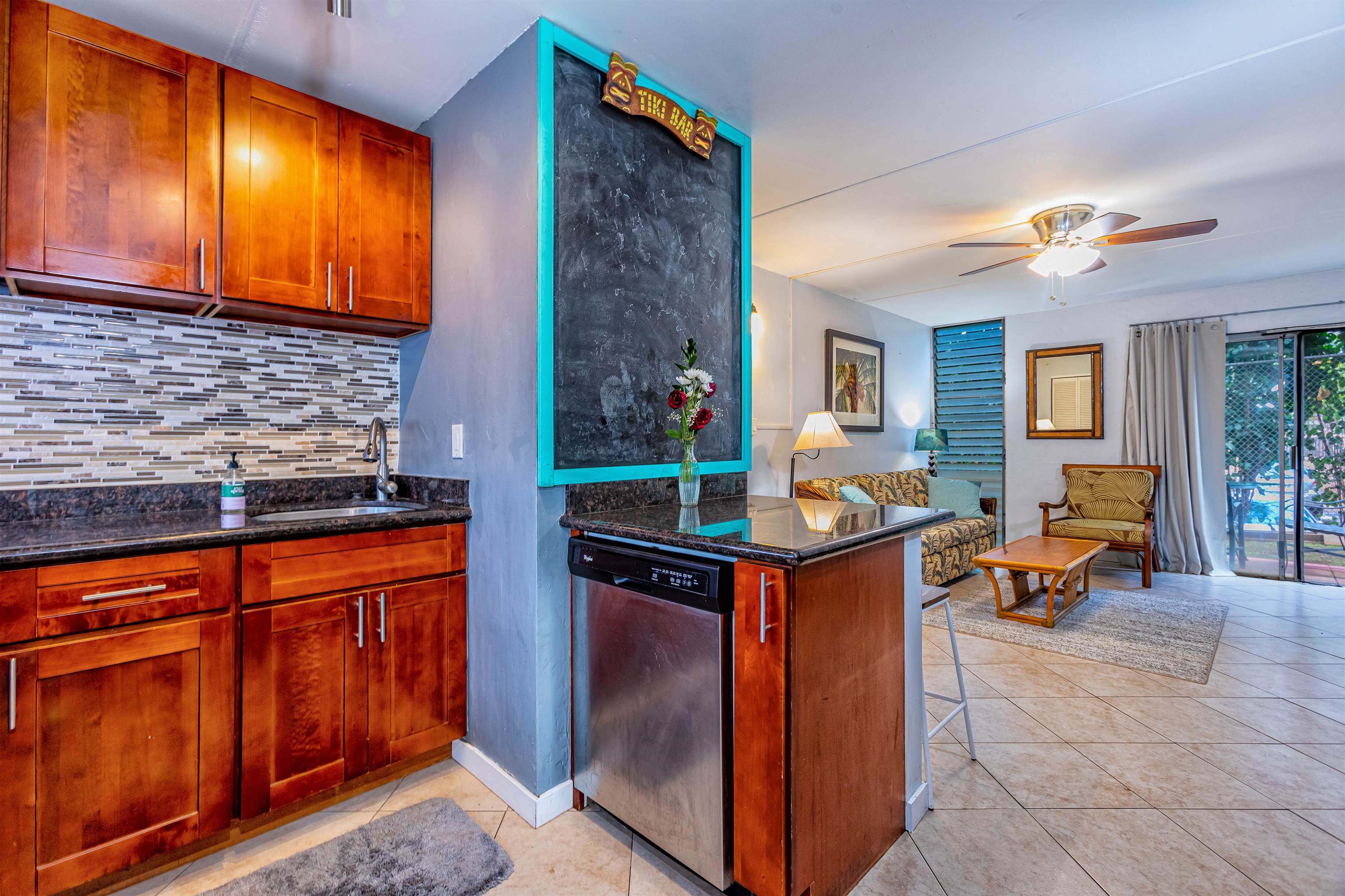 3676 Lower Honoapiilani Road, Unit D102 Lahaina, HI 96761 - Photo 1 of 24 a kitchen with stainless steel appliances granite countertop wooden cabinets a sink and a refrigerator