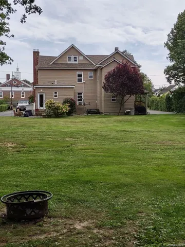a view of a big house with a big yard and potted plants