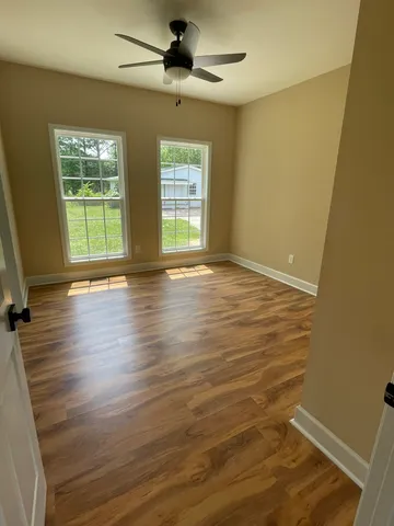 a view of empty room with window and ceiling fan