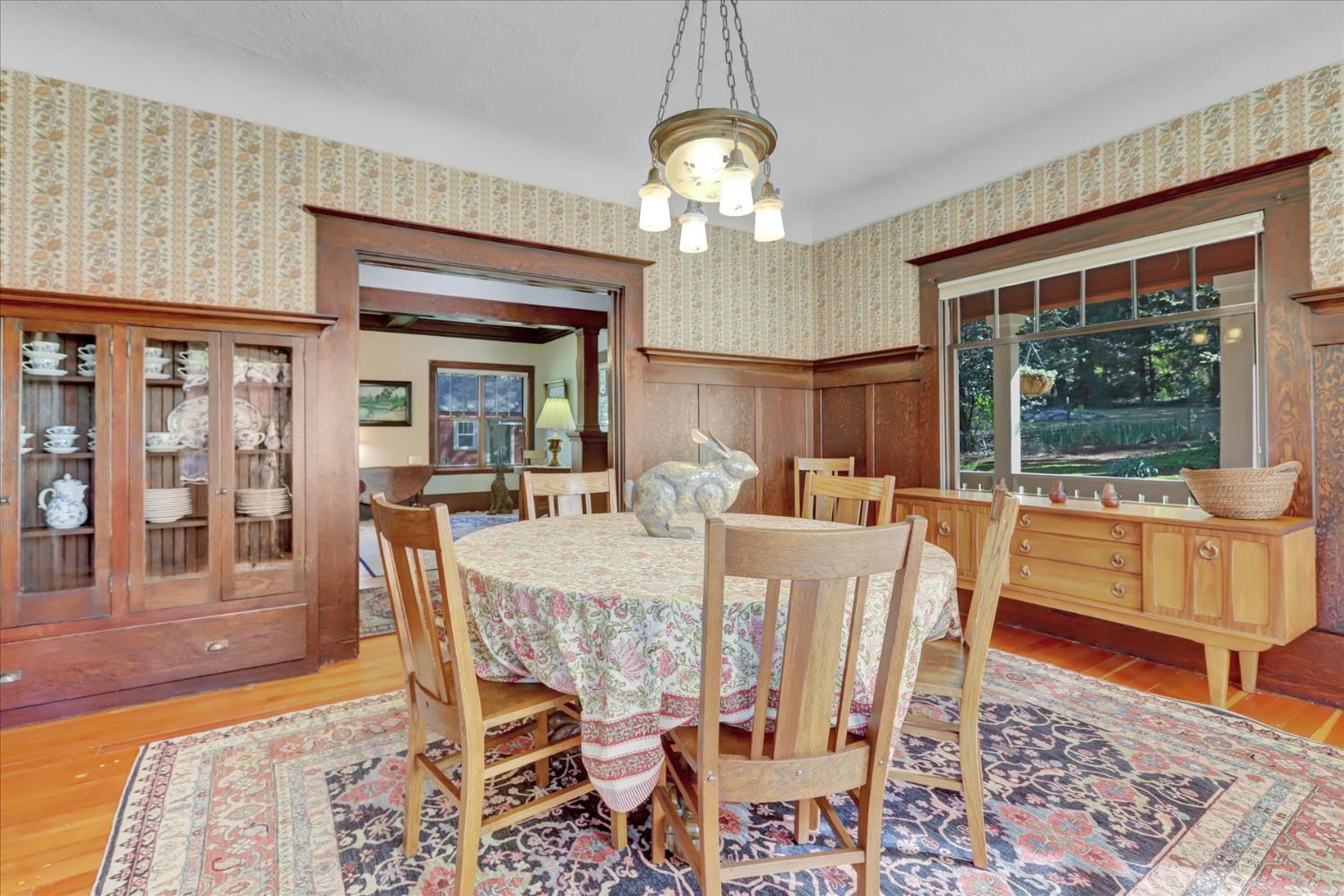 12562 Rough And Ready Highway Grass Valley, CA 95945 - Photo 27 of 99 a dining room with wooden floor a chandelier a wooden table and chairs