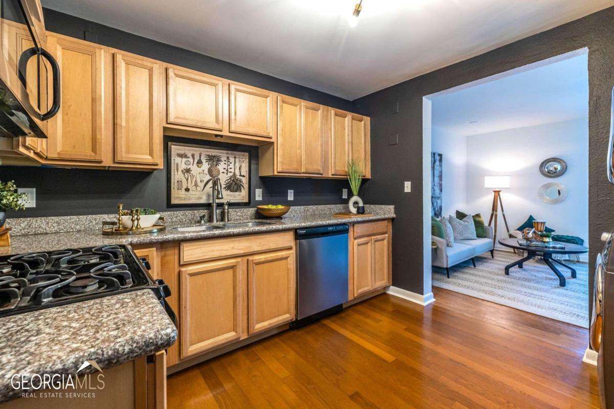 a kitchen with stainless steel appliances granite countertop a stove a sink dishwasher and cabinets with wooden floor