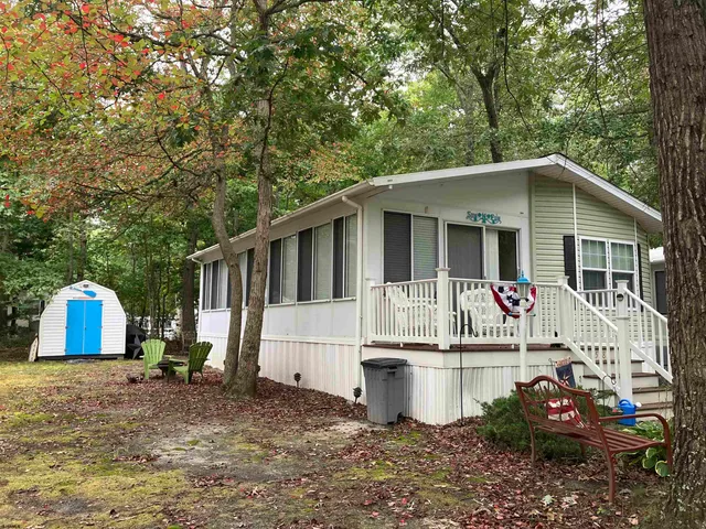 a view of a white house with a sink and a yard