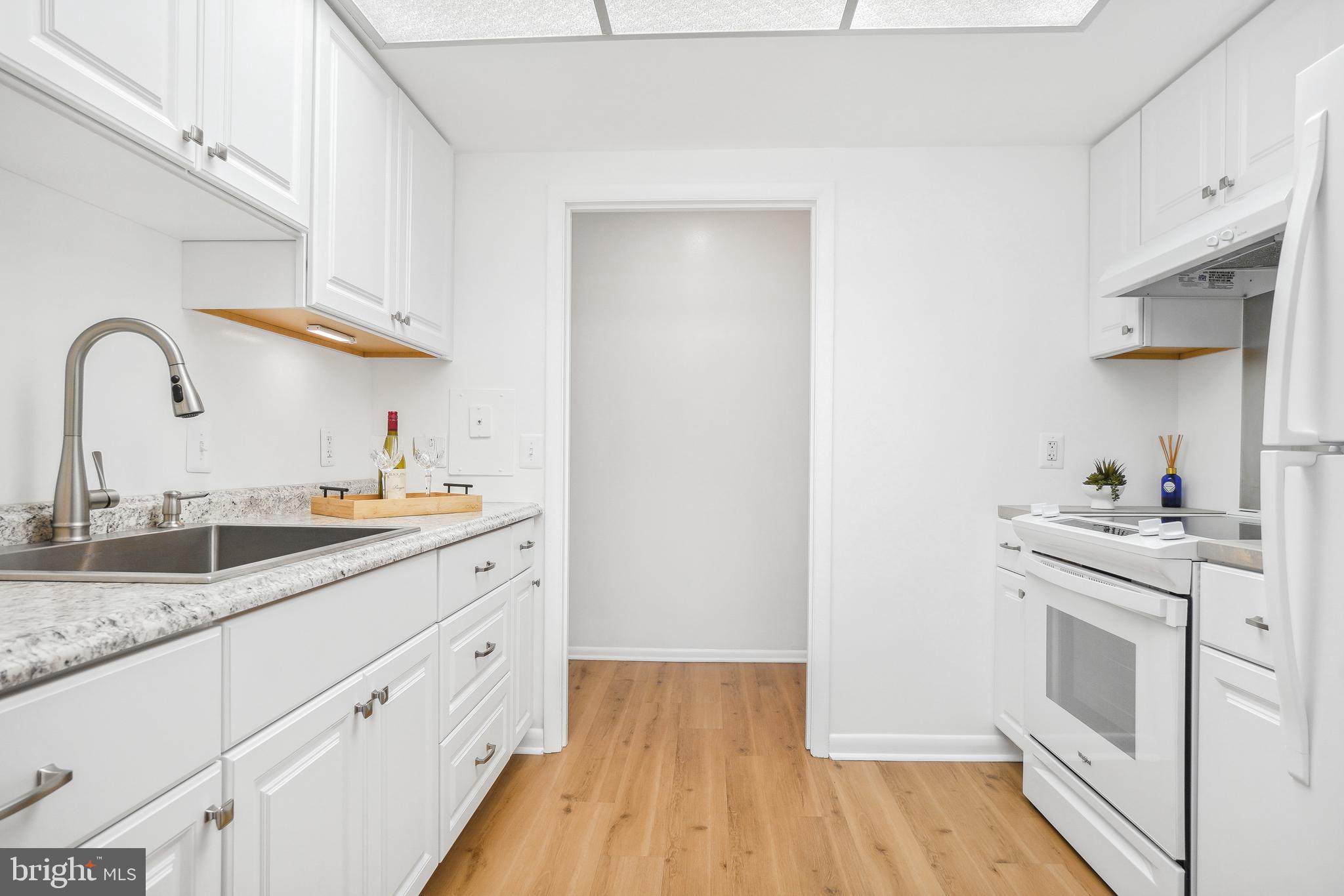 3350 Chiswick Court, Unit 573C Silver Spring, MD 20906 - Photo 5 of 43 a kitchen with a sink cabinets and wooden floor