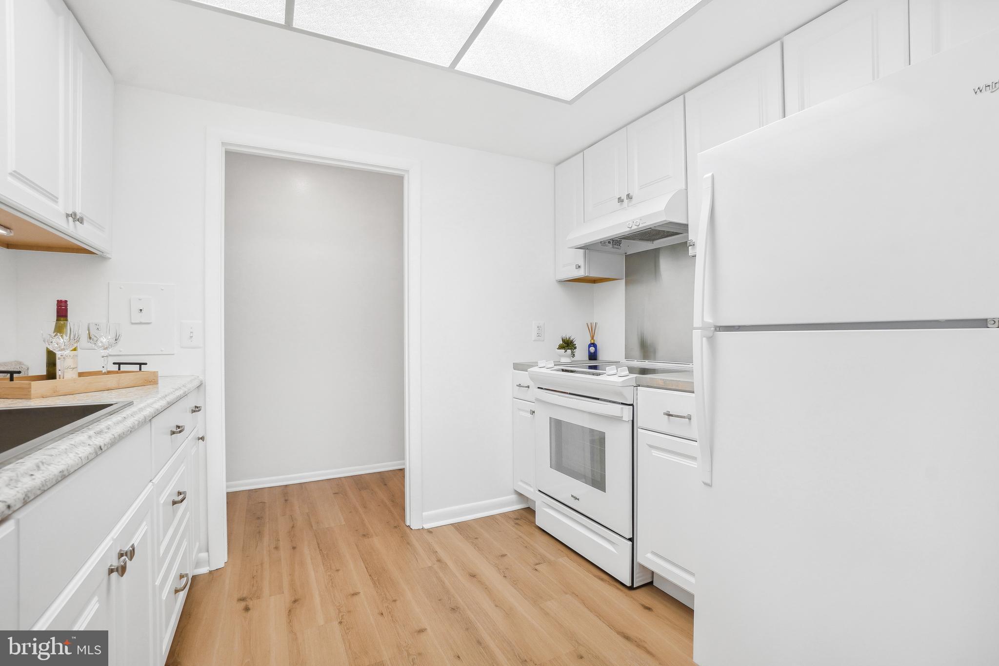 3350 Chiswick Court, Unit 573C Silver Spring, MD 20906 - Photo 6 of 43 a kitchen with white cabinets and white appliances