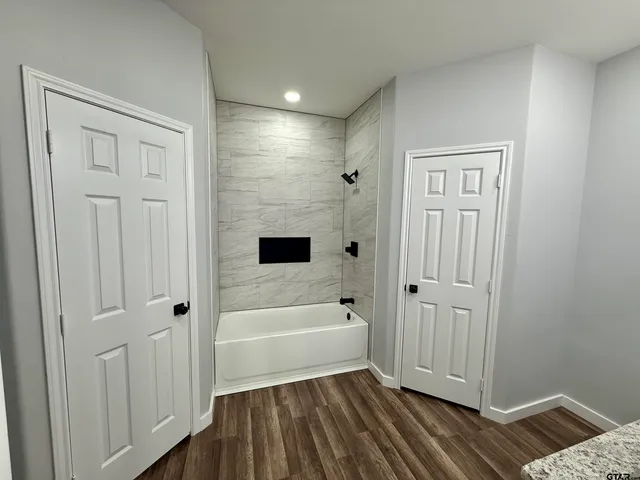 a bathroom with a tub shower and sink