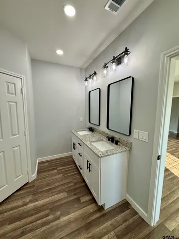 a bathroom with a granite countertop sink and a mirror