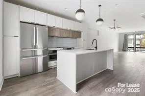 a kitchen with kitchen island a sink stainless steel appliances and refrigerator